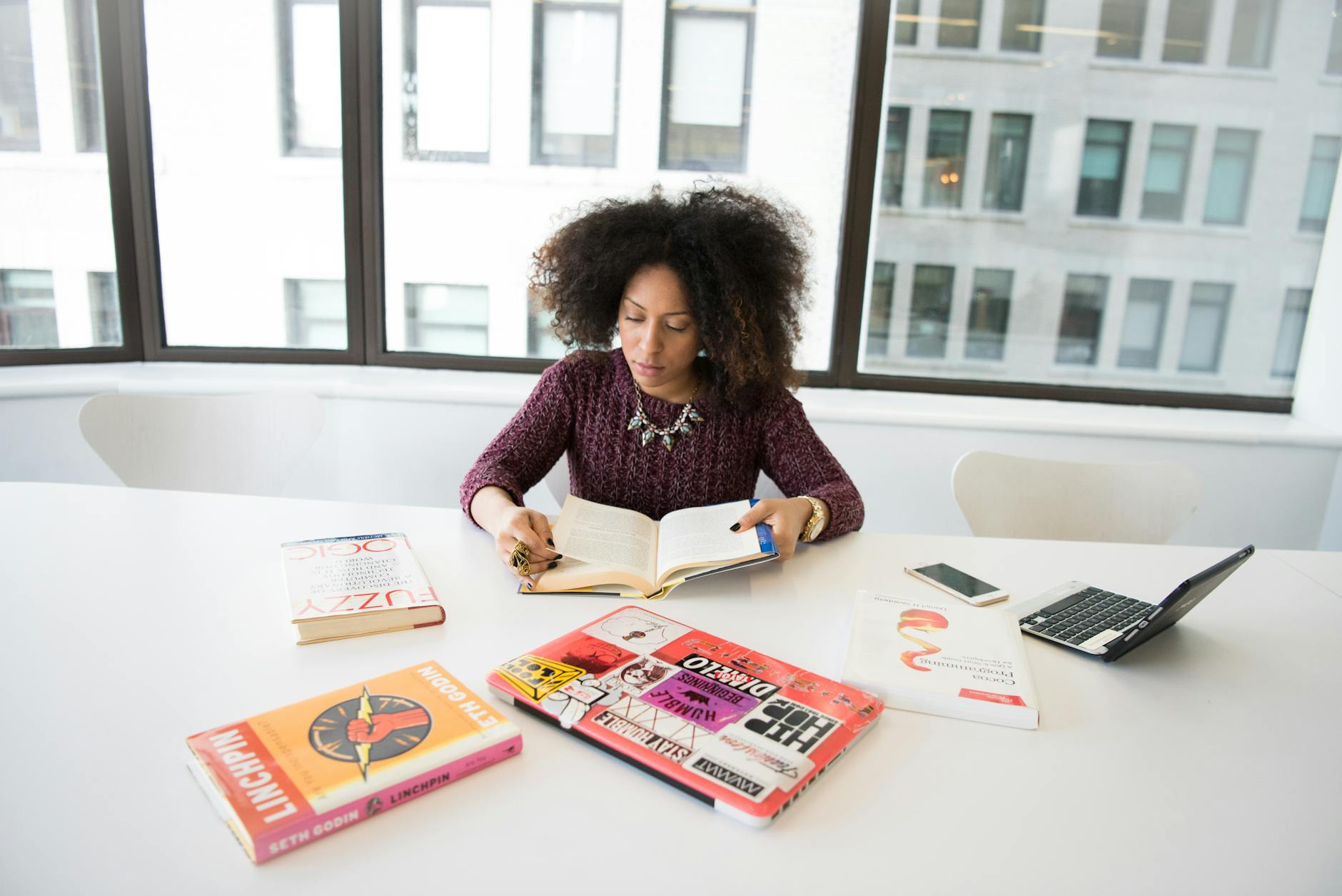 A focused woman working in an office environment, studying and reading research material — TransferCredit.org