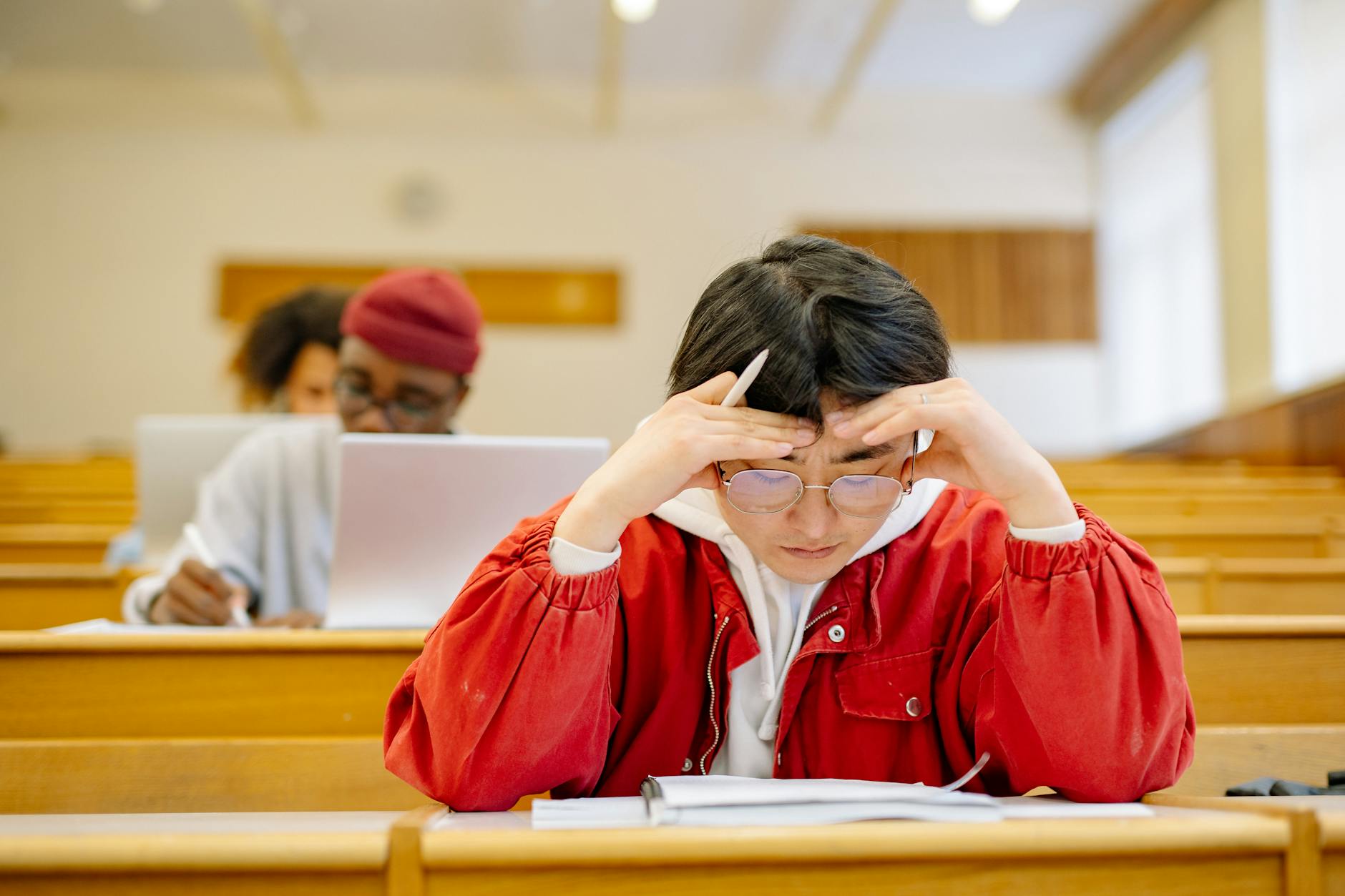 Focused students studying intensely in a university lecture hall setting — TransferCredit.org