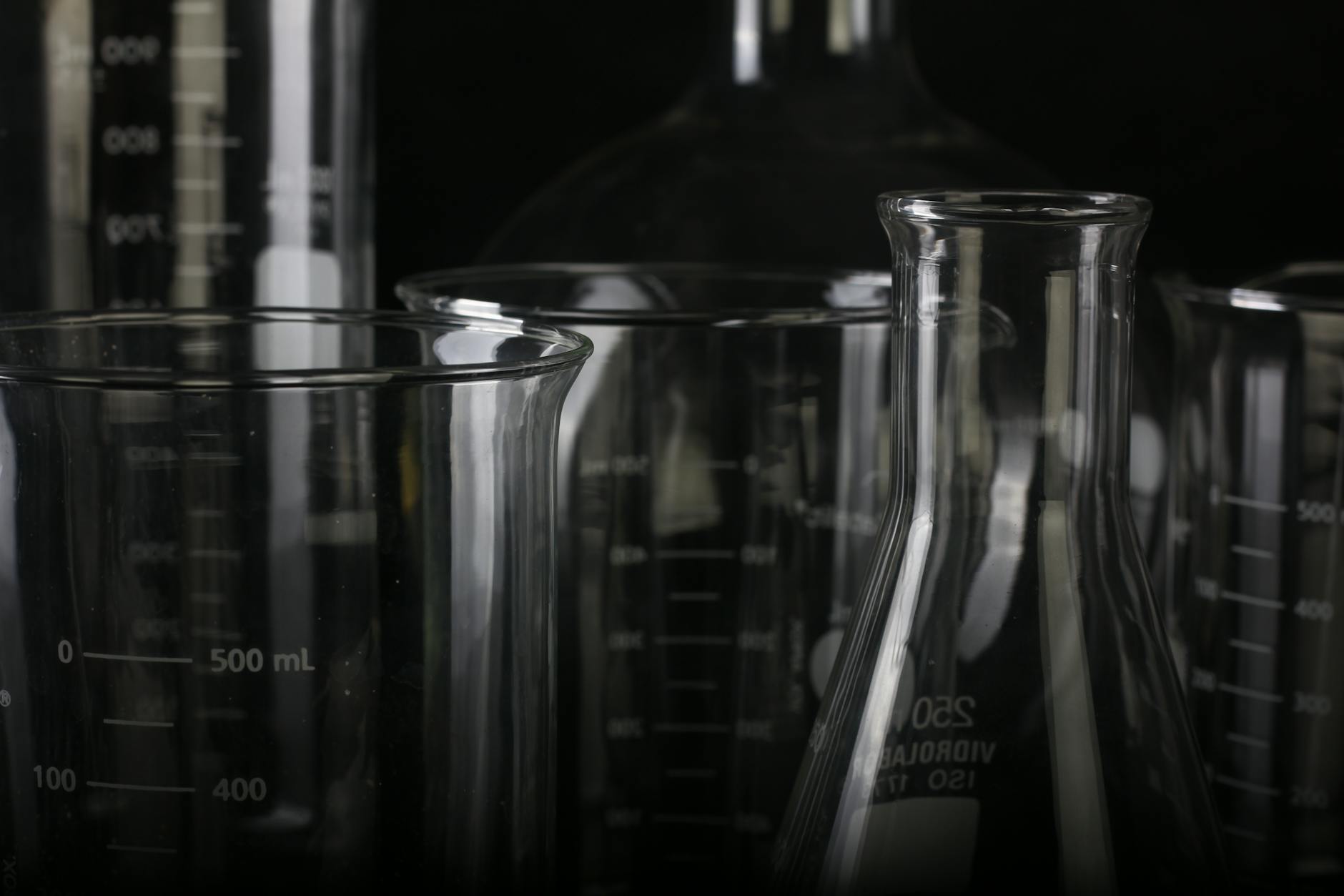 A detailed close-up of various transparent laboratory glassware used in scientific experiments — TransferCredit.org