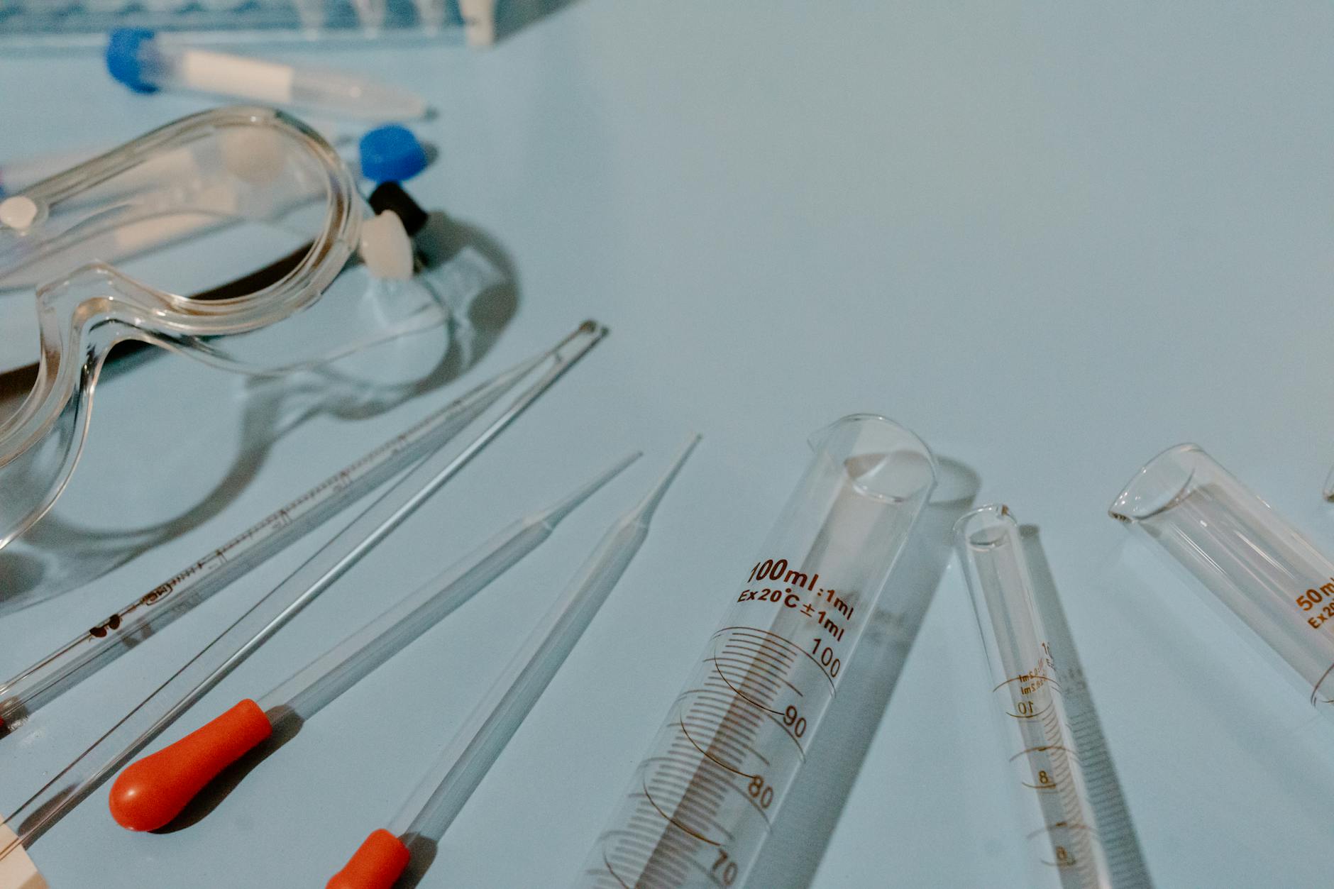 Detailed view of lab equipment like test tubes and goggles on a blue surface — TransferCredit.org