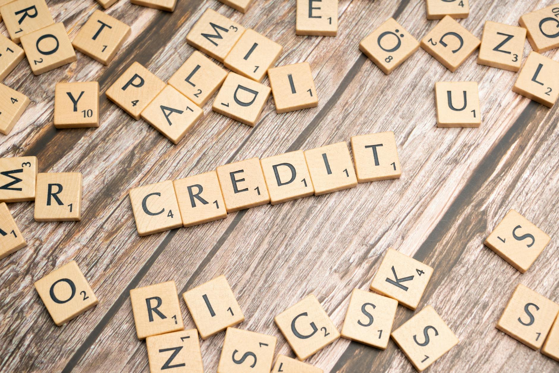 Wooden letter tiles arranged to spell 'CREDIT' on a rustic table background — TransferCredit.org