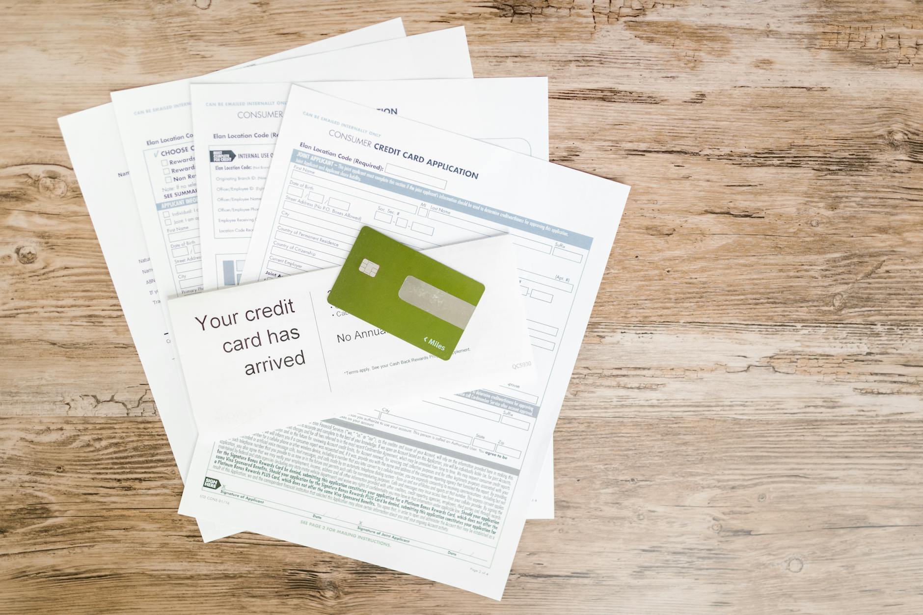 Top view of credit card and application documents on wooden surface — TransferCredit.org