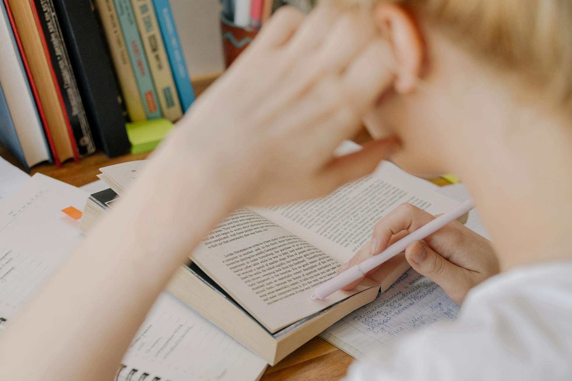 A student studying diligently with an open textbook, emphasizing concentration and learning — TransferCredit.org
