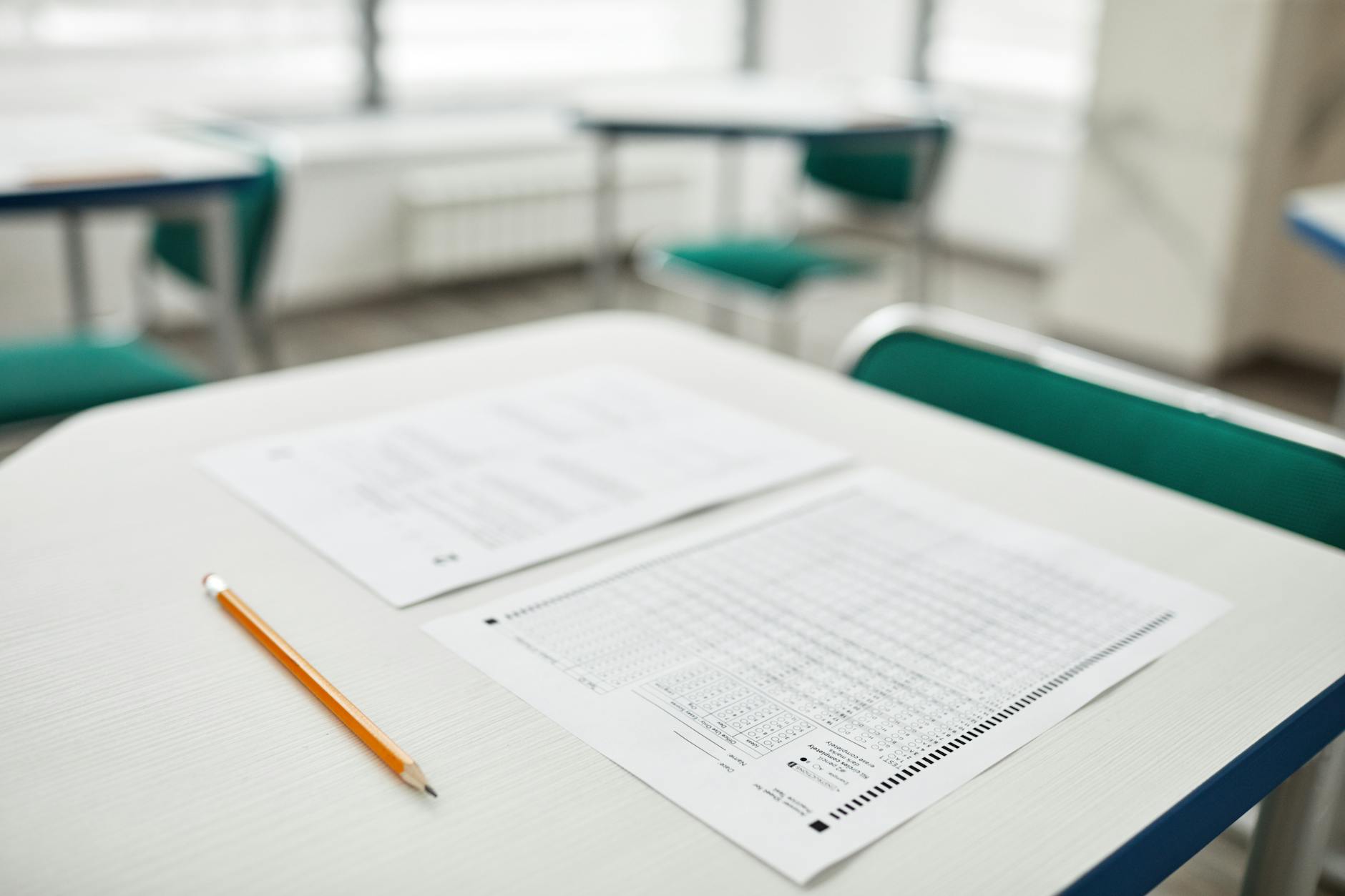 Close-up of exam papers and a pencil on a classroom desk, ready for a test — TransferCredit.org