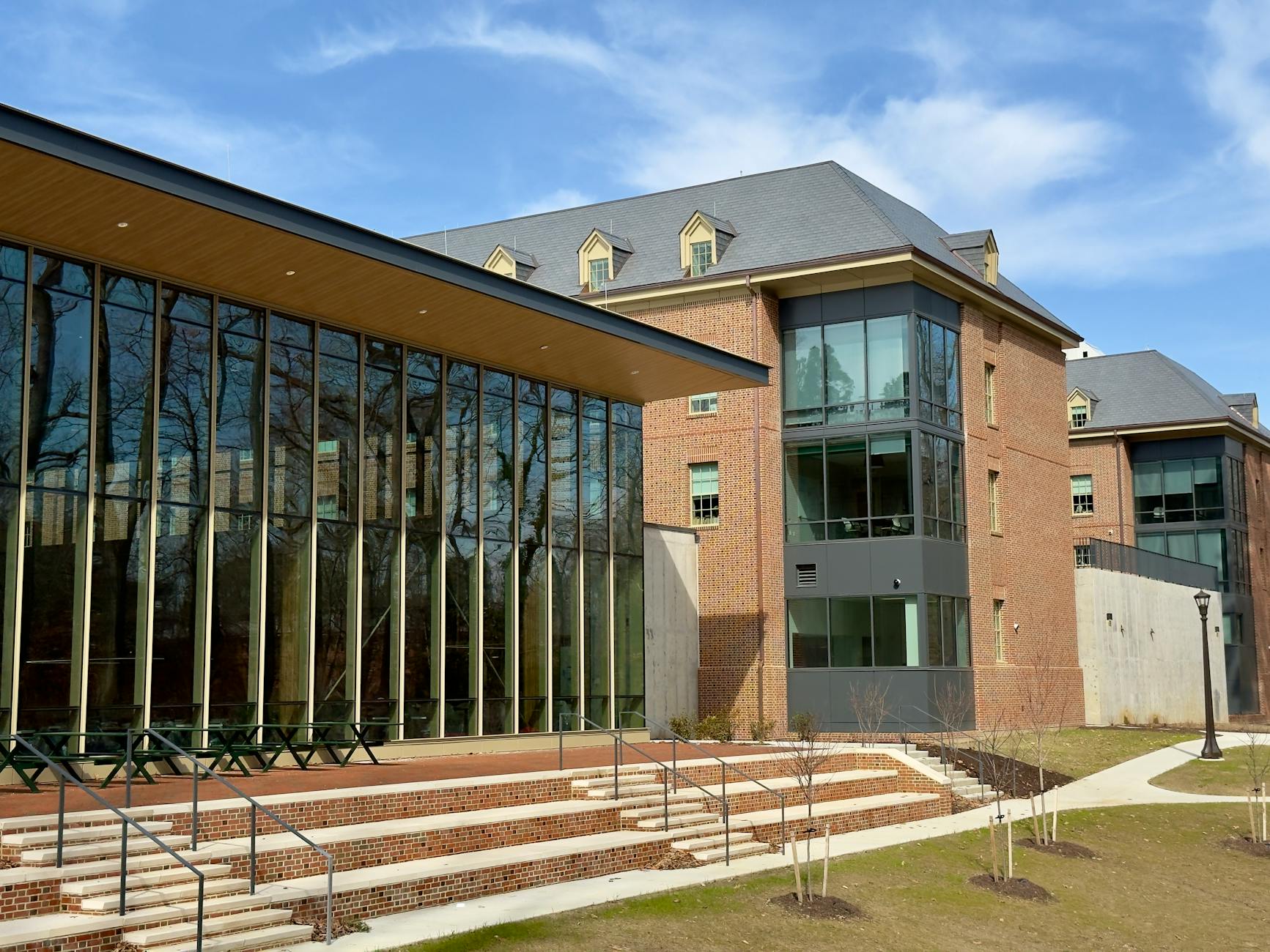 Exterior view of a modern academic building featuring large glass windows and brick architecture on a sunny day — TransferCredit.org