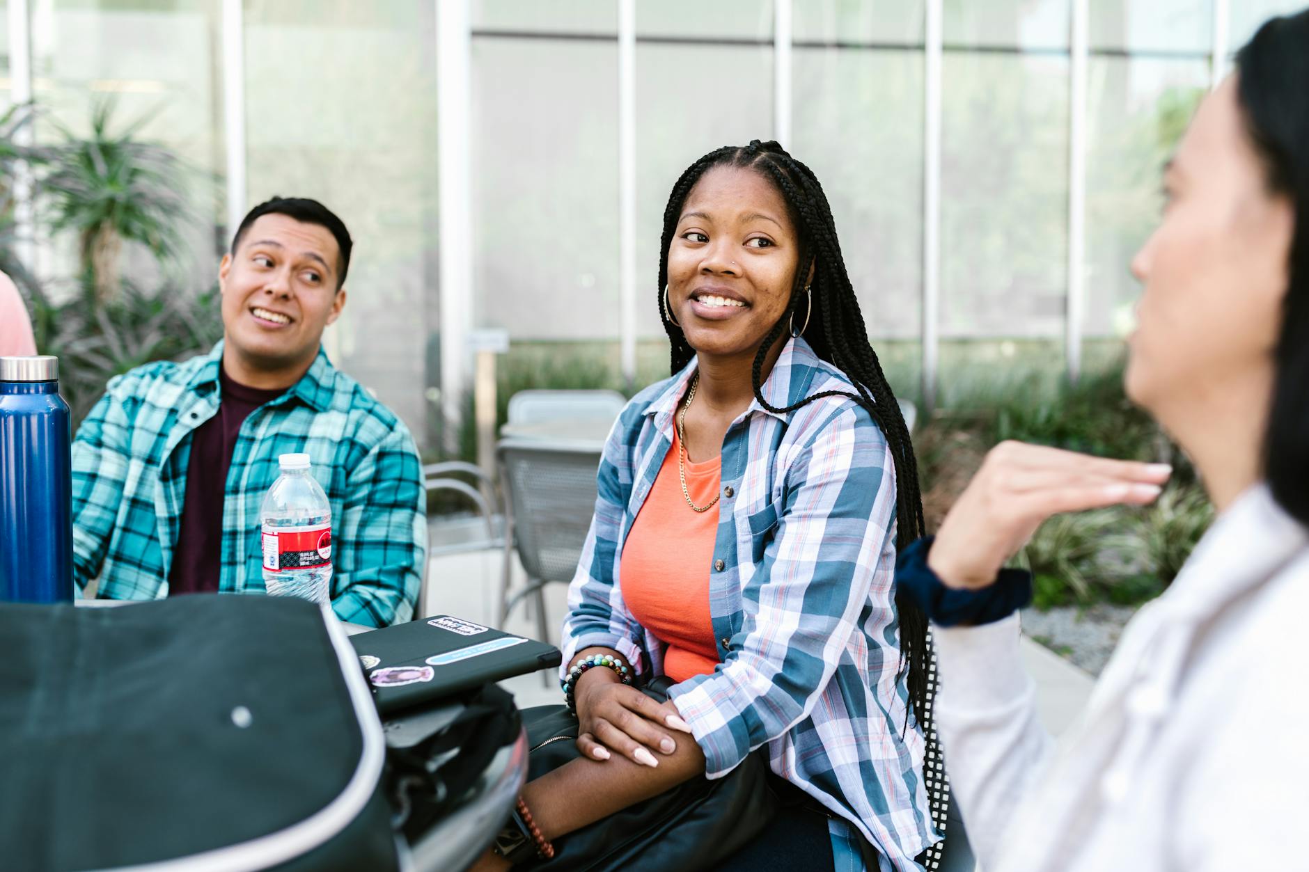 A group of diverse college students having a conversation outside in a relaxed campus setting — TransferCredit.org