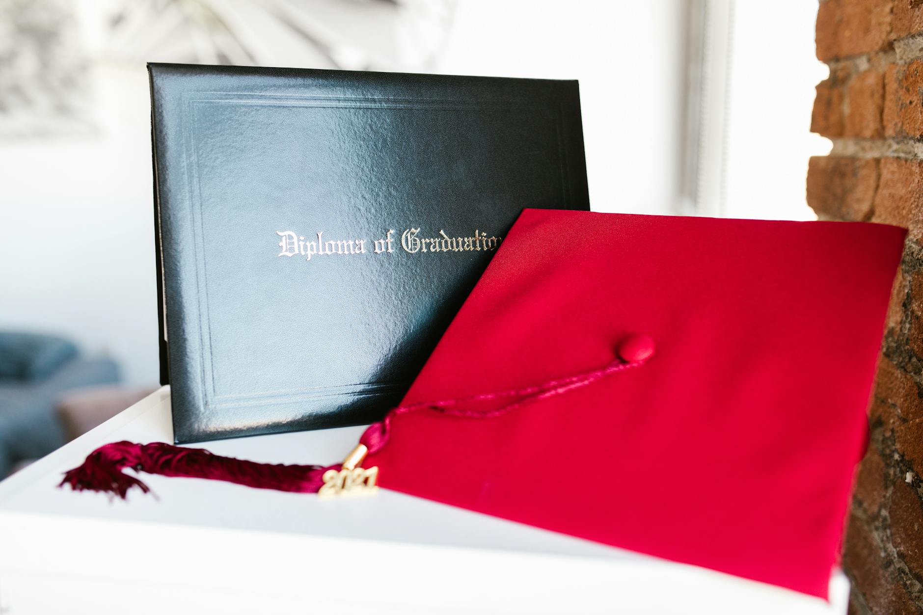 Close-up of a vibrant red graduation cap and diploma, symbolizing achievement — TransferCredit.org