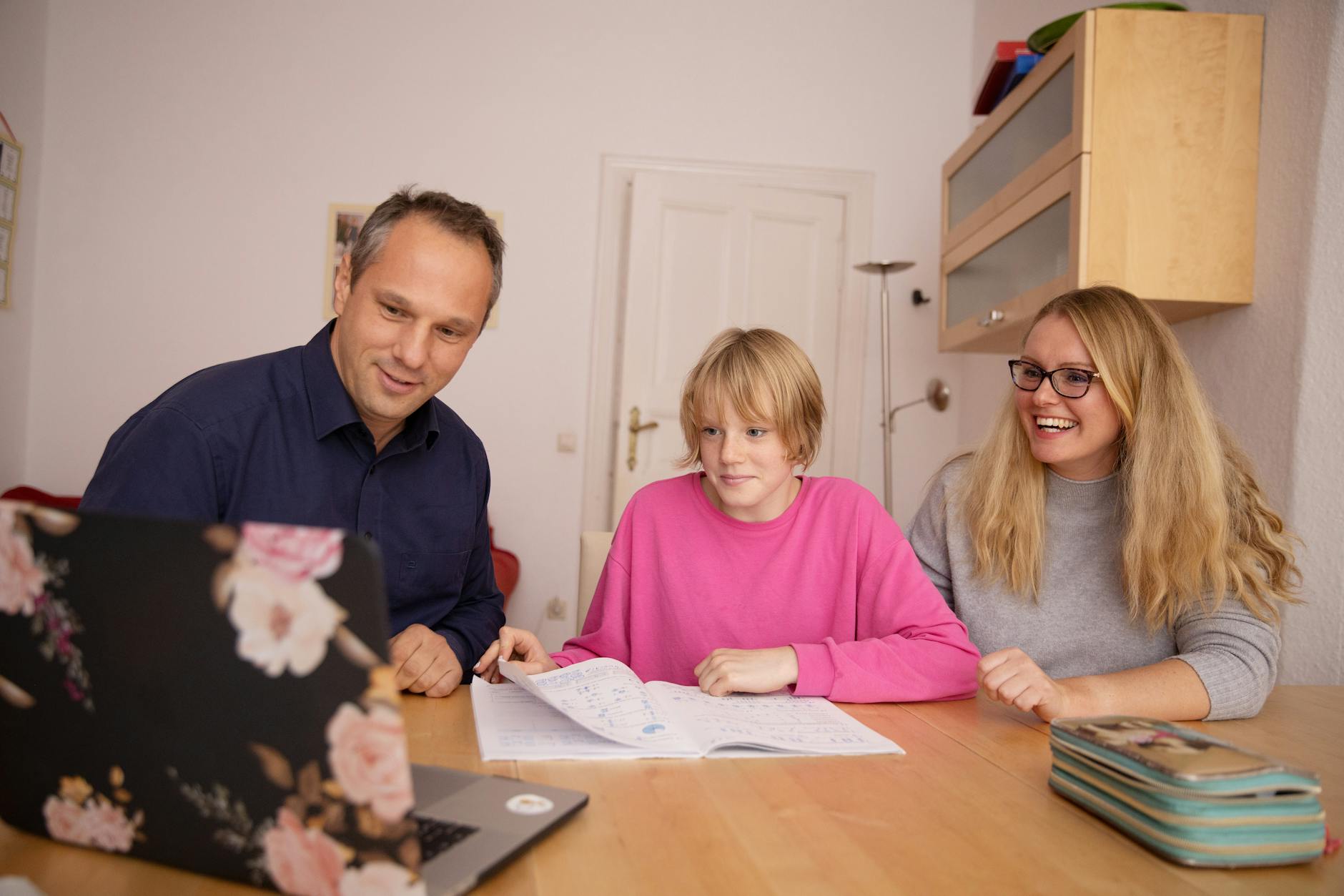 Family engaged in online learning together at home using laptop, focusing on education and connection — TransferCredit.org