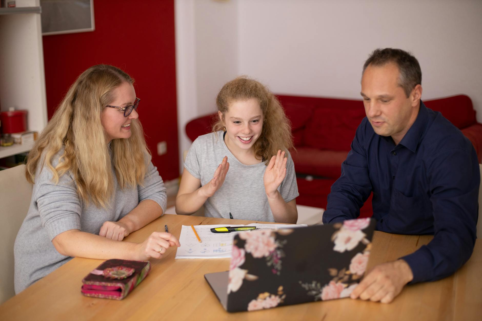 A family happily engaged in remote learning at home using a laptop. Educational collaboration — TransferCredit.org