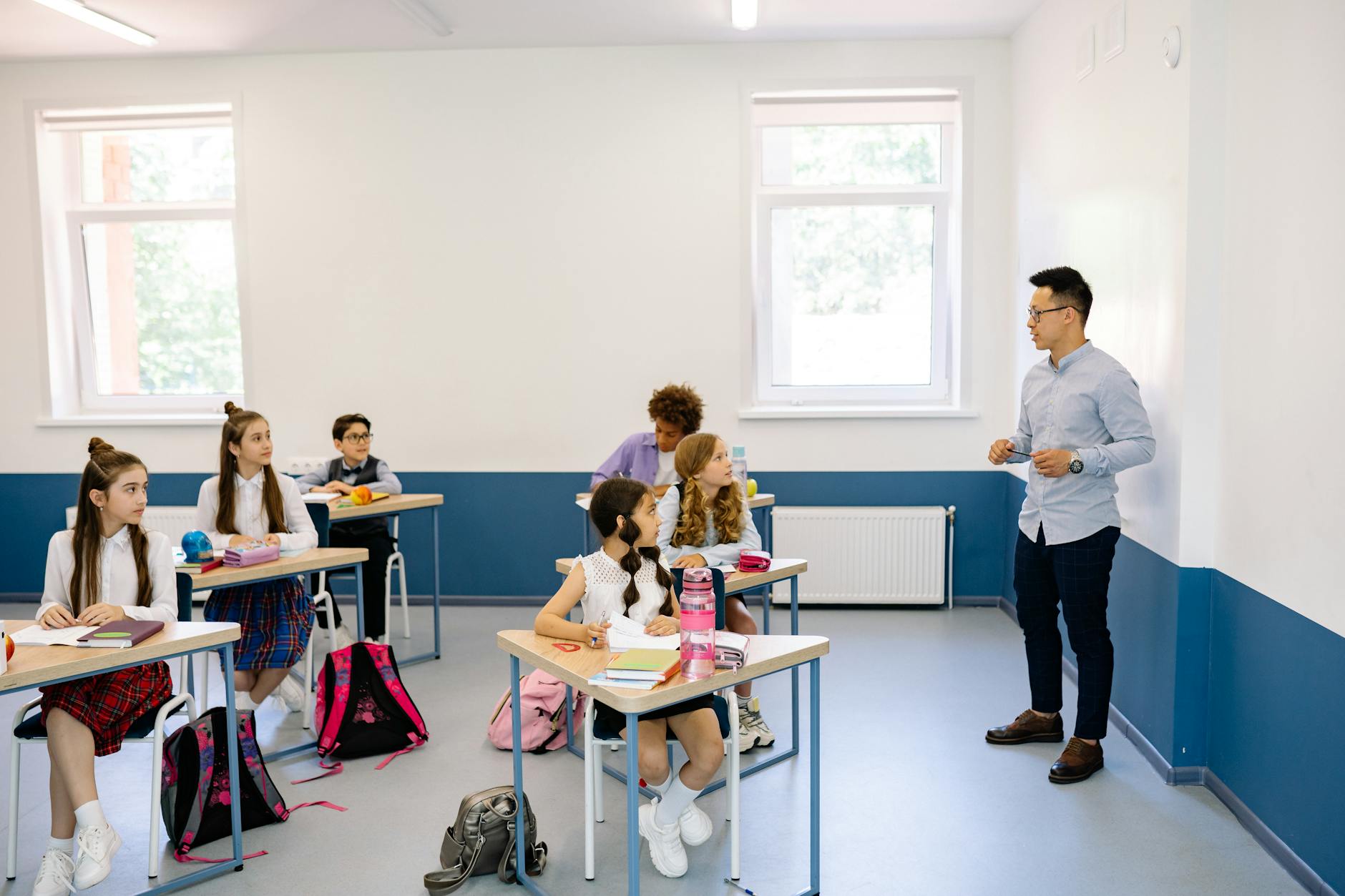 Students attentively listening to a teacher during a classroom lesson — TransferCredit.org