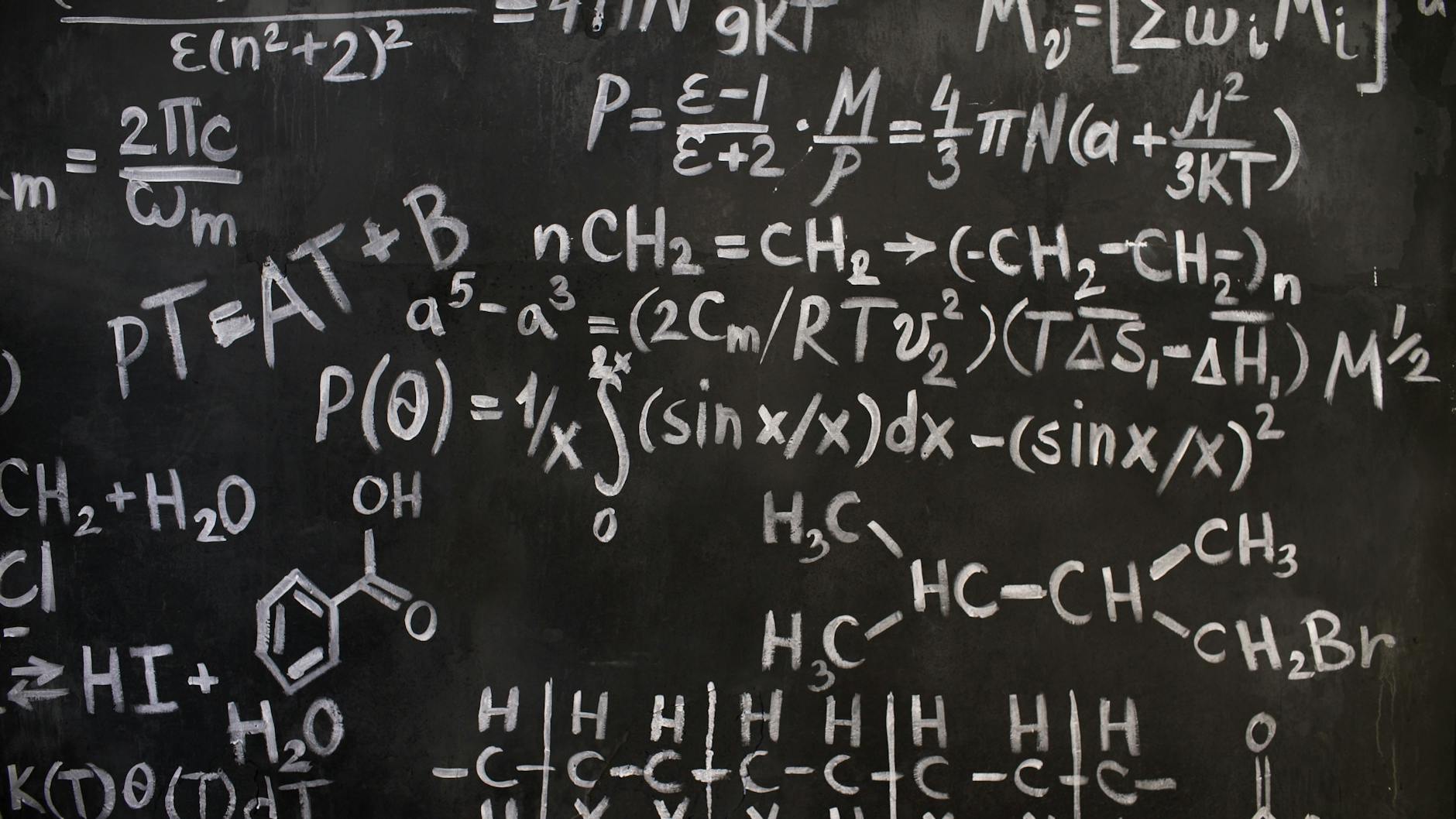 A close-up view of complex mathematical and chemical formulas on a blackboard — TransferCredit.org