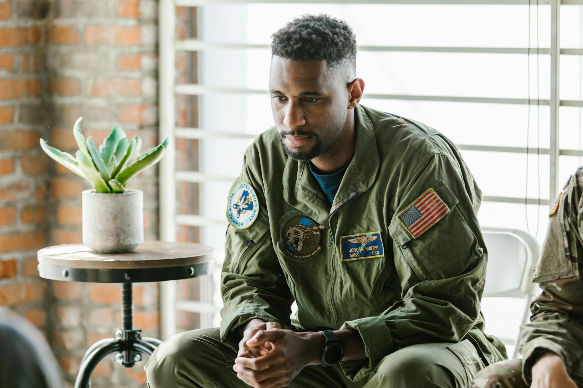 Thoughtful military veteran in uniform listening intently indoors — TransferCredit.org