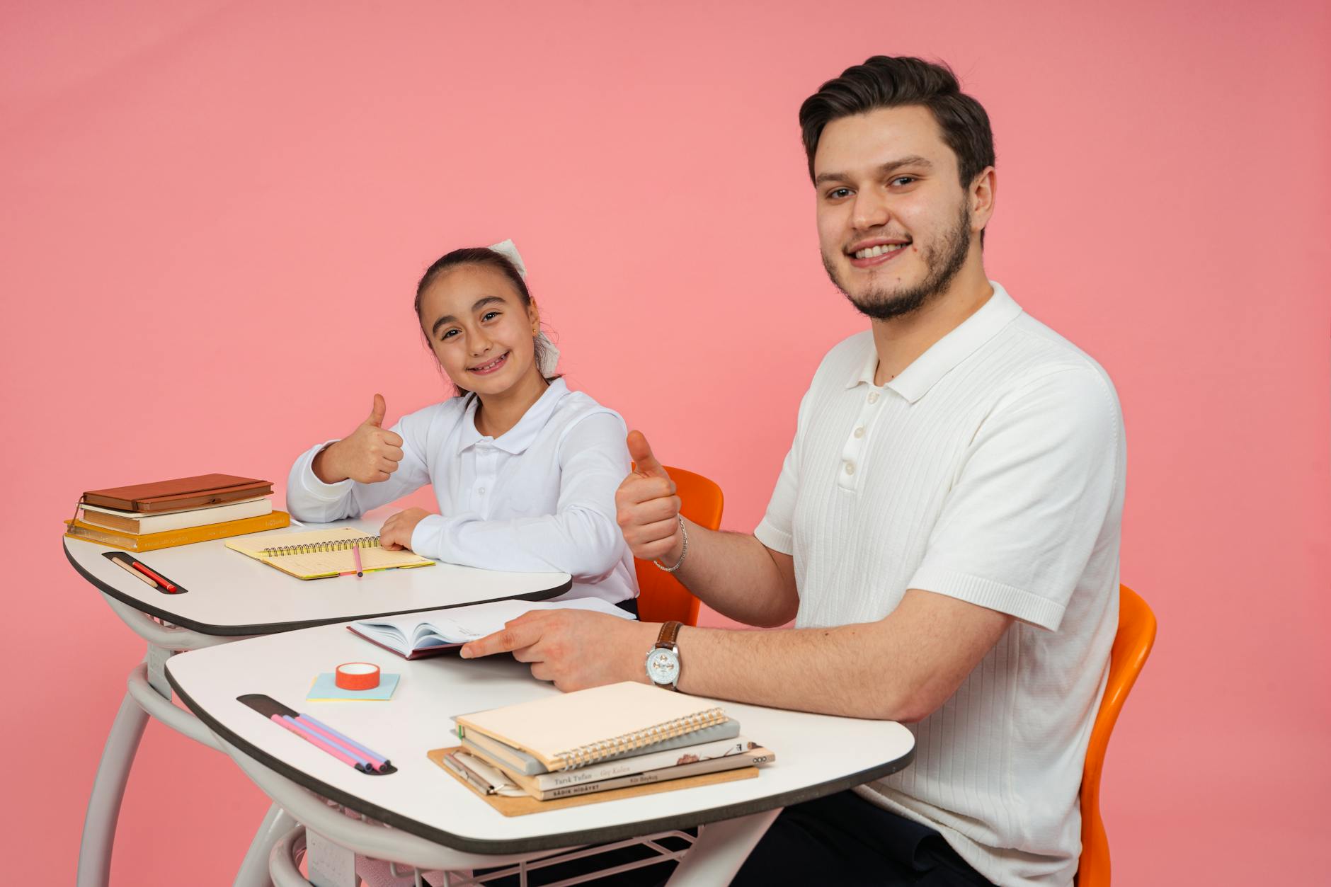 Smiling teacher and student at a desk, thumbs up, promoting education and positivity — TransferCredit.org