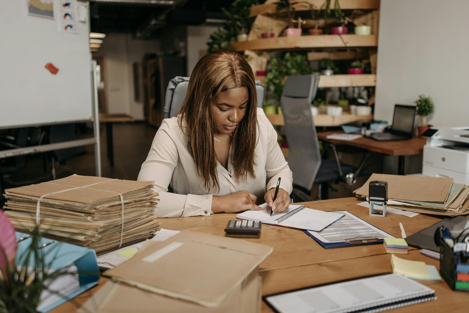 Businesswoman focused on paperwork in an organized office setting — TransferCredit.org