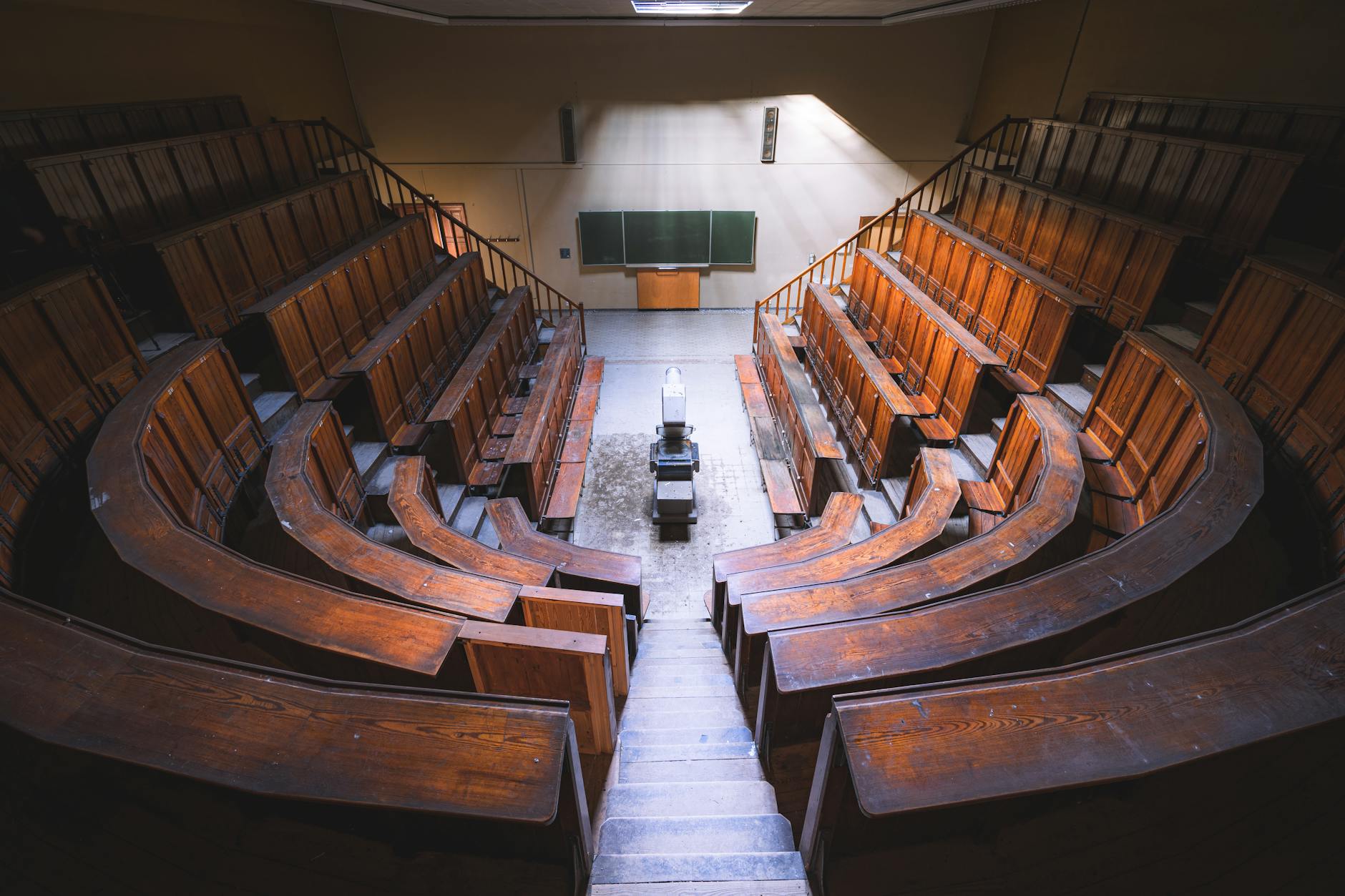 Empty vintage lecture hall with wooden benches and chalkboard, viewed from above — TransferCredit.org
