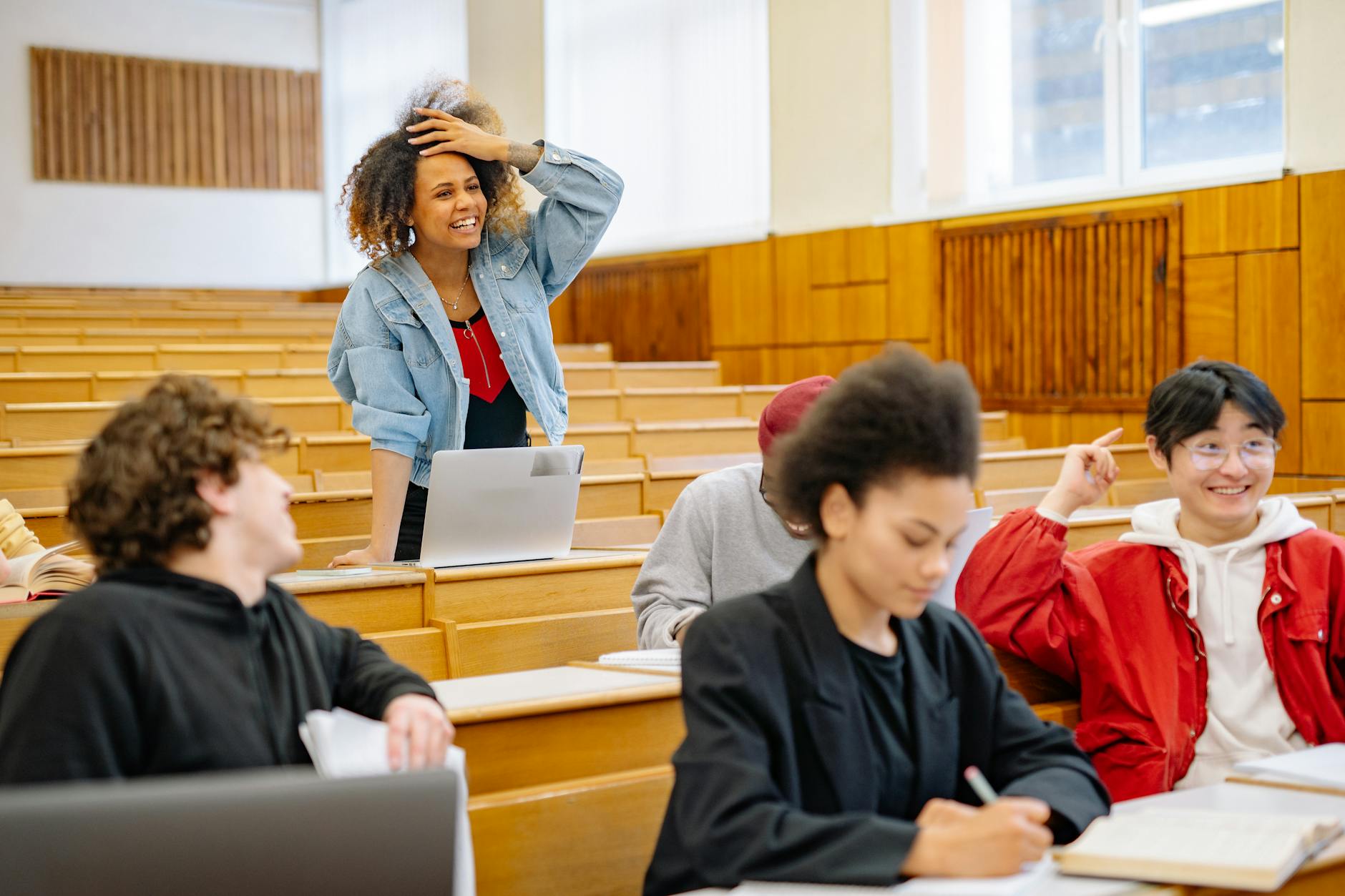 Students in a university lecture hall interacting and studying together — TransferCredit.org