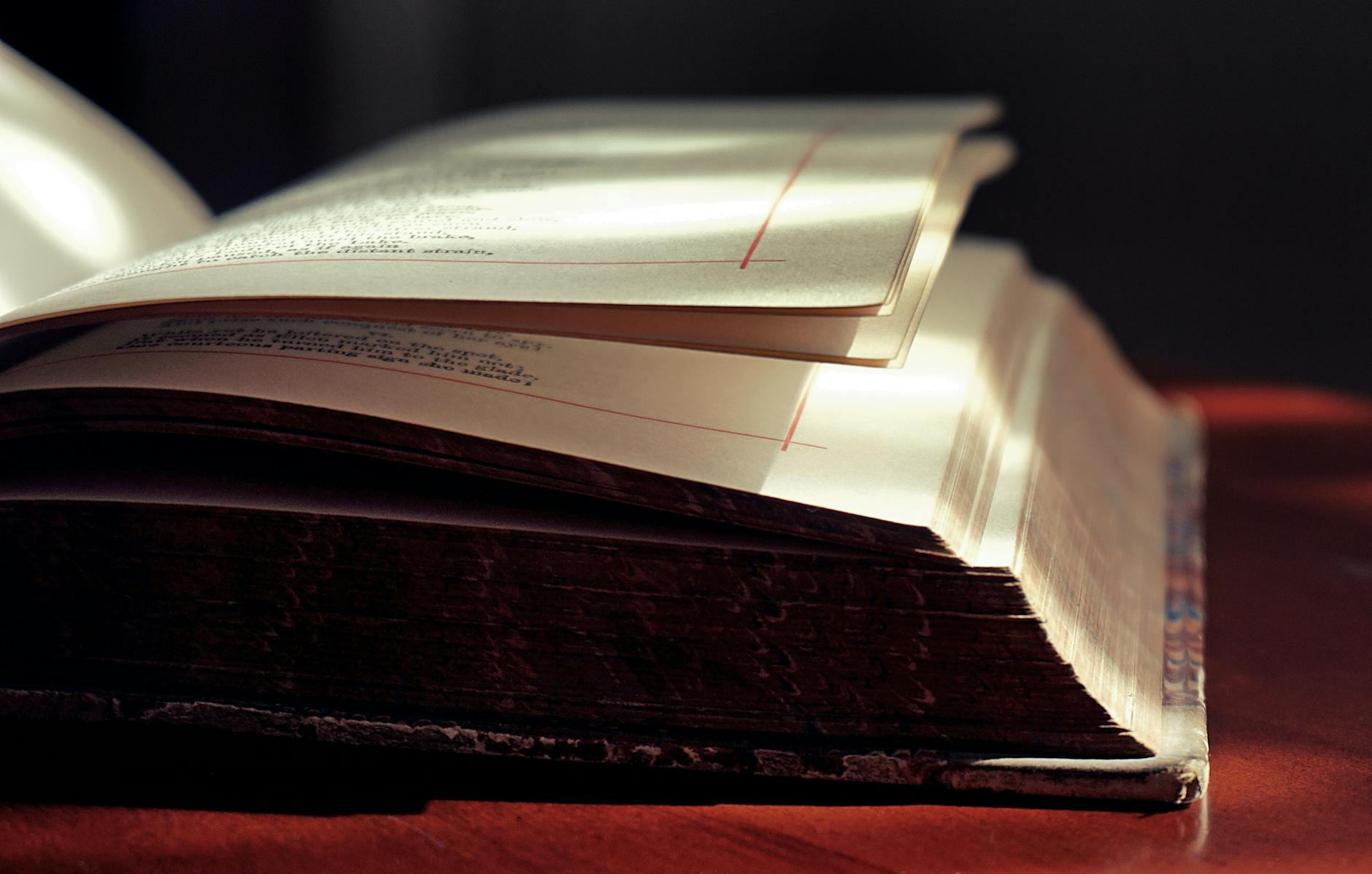 Artistic close-up of an open hardcover book in soft lighting, highlighting the texture of the pages — TransferCredit.org