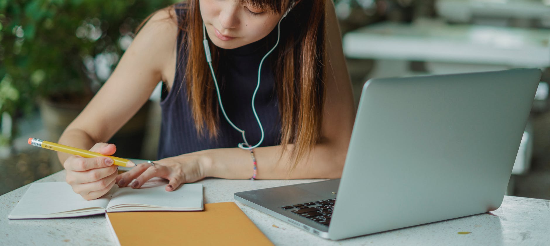 A young woman takes notes while studying with a laptop. Ideal for educational and lifestyle concepts — TransferCredit.org