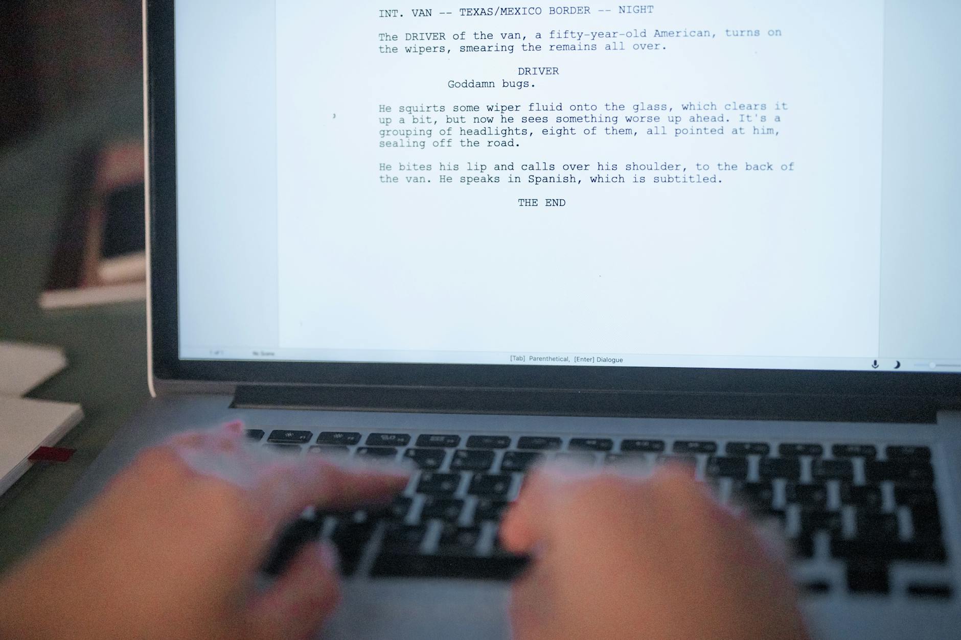 A close-up shot of hands typing a film script on a laptop, focusing on creativity and screenplay writing — TransferCredit.org